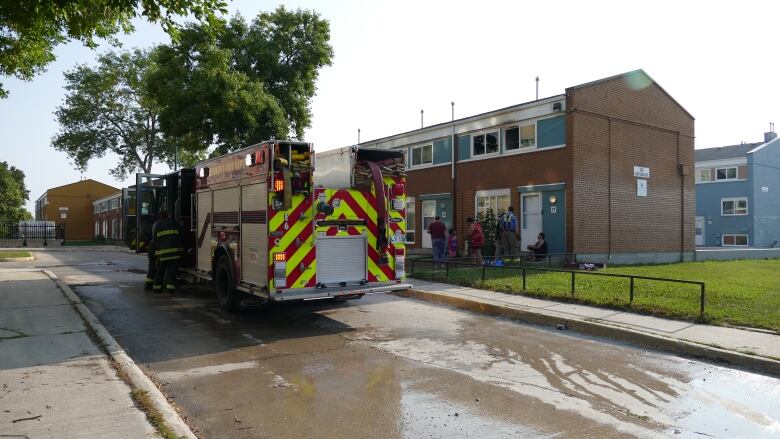 A fire truck sits outside a townhouse.