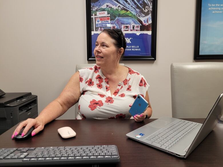 Picture of realtor looking at her computer in office. 