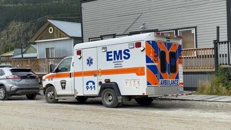 An ambulance parked infront of a building.