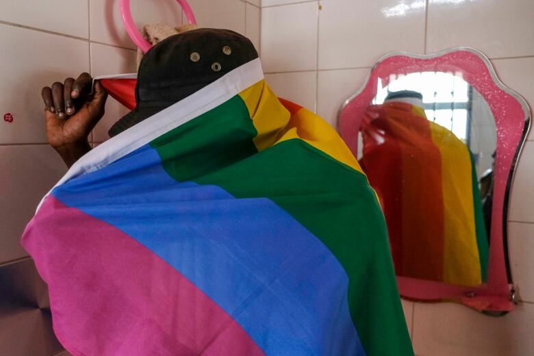 A man covers himself with a pride flag.