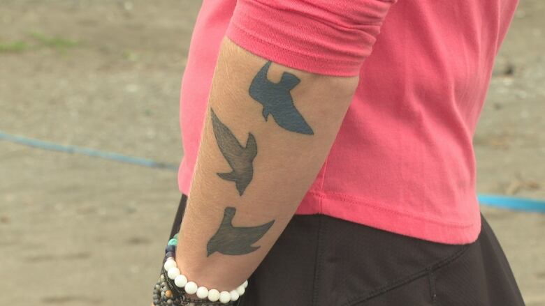 A picture of a tattoo of three birds that has been inked onto Kim's forearm. All the birds are shaded dark in colour.