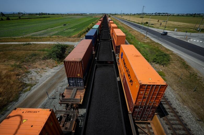 Cargo containers and cars carrying coal sit idle on rail lines leading to Deltaport during a strike by International Longshore and Warehouse Union Canada workers in the province, in Delta, B.C., on Friday, July 7, 2023.