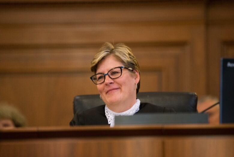 A female judge sits behind the bench