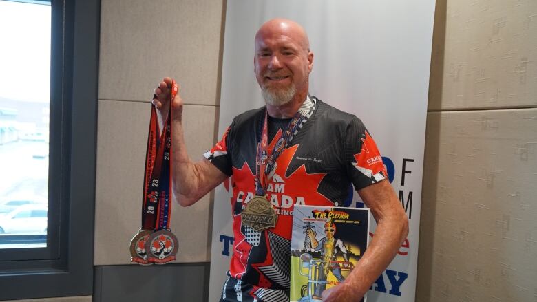 A smiling man displays medals.