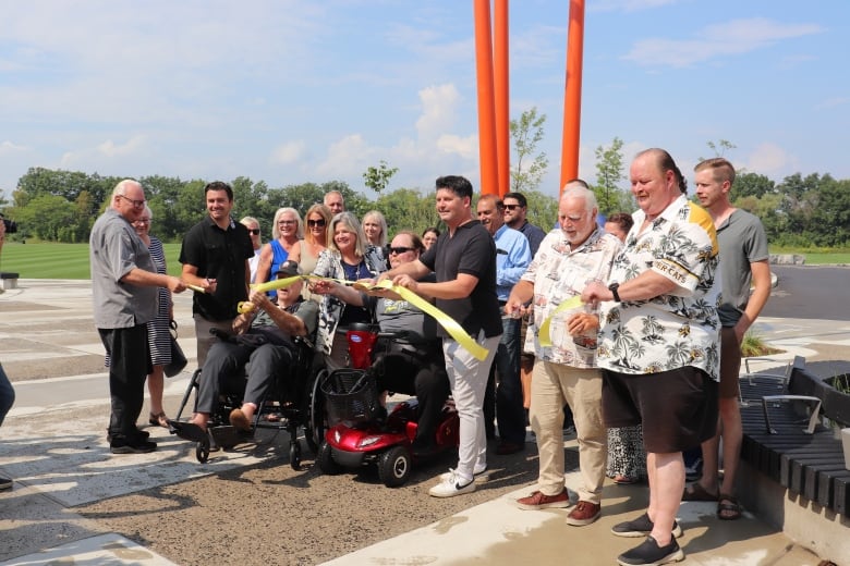 Family and politicians cutting a yellow ribbon. 