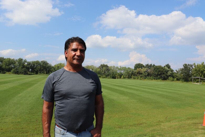 Man in front of cricket pitch