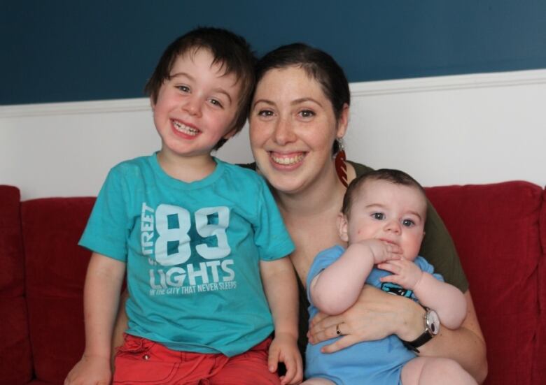 A mother and her two sons on a couch. 