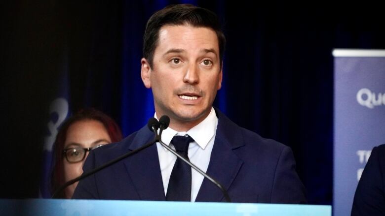 Young man in suit and tie at a mic stand.