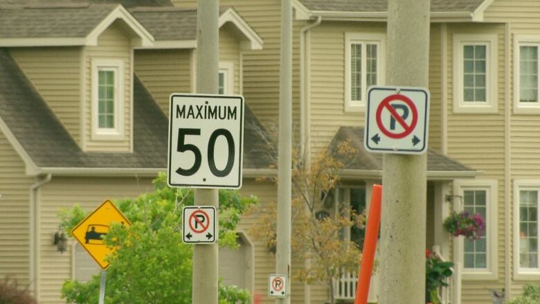 A traffic sign in front of a house says Maximum 50.