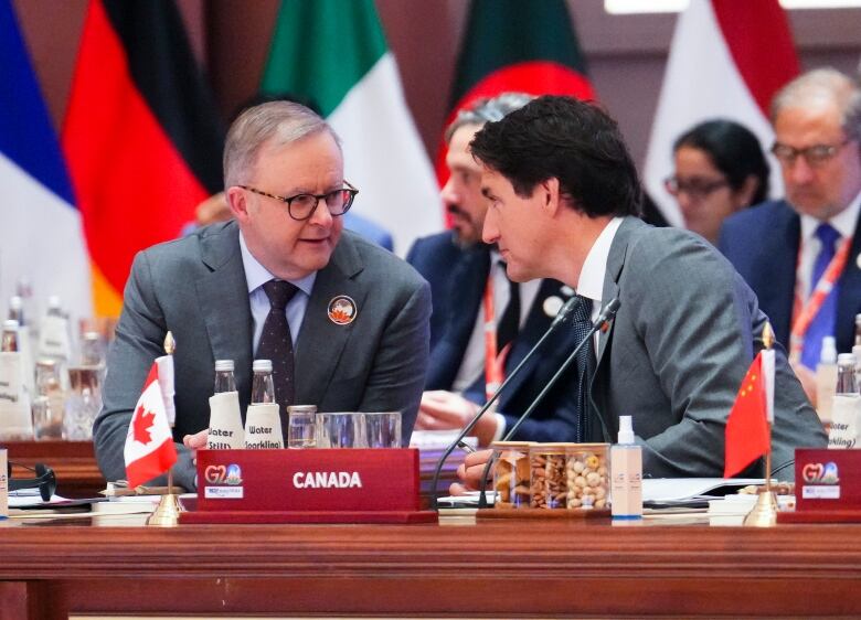 Two men chat while seated.