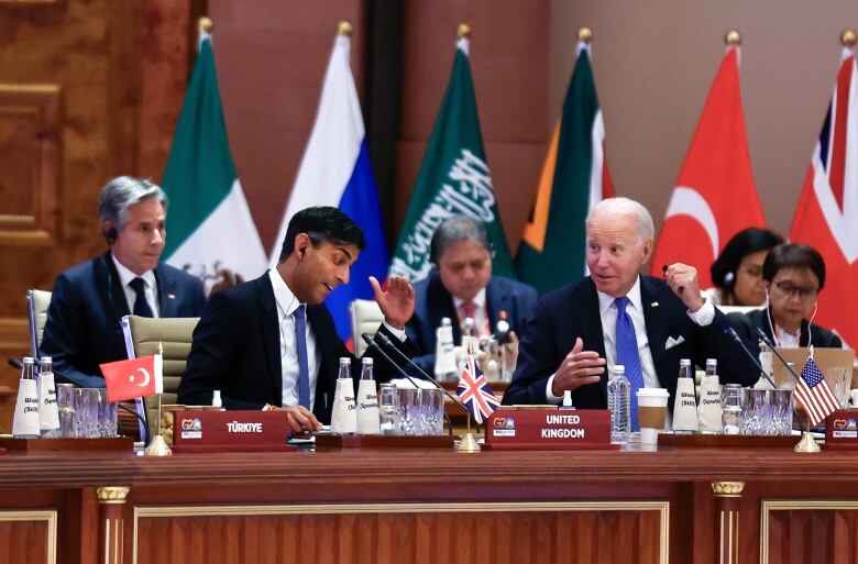 Two men talk while seated.