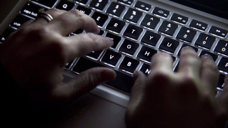 A person types on a keyboard.