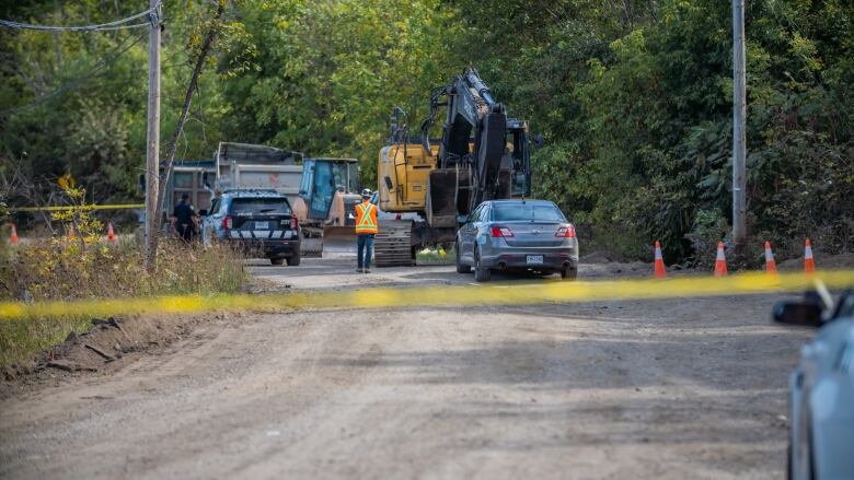 Police cars and police tape seen on a construction site. 