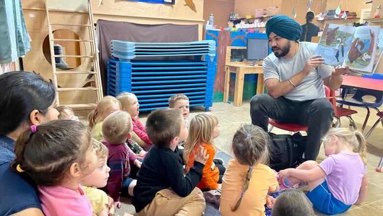 Child-care working reading a book to kids.