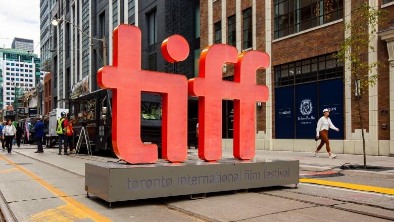 A large red logo reading TIFF stands in the middle of a street.