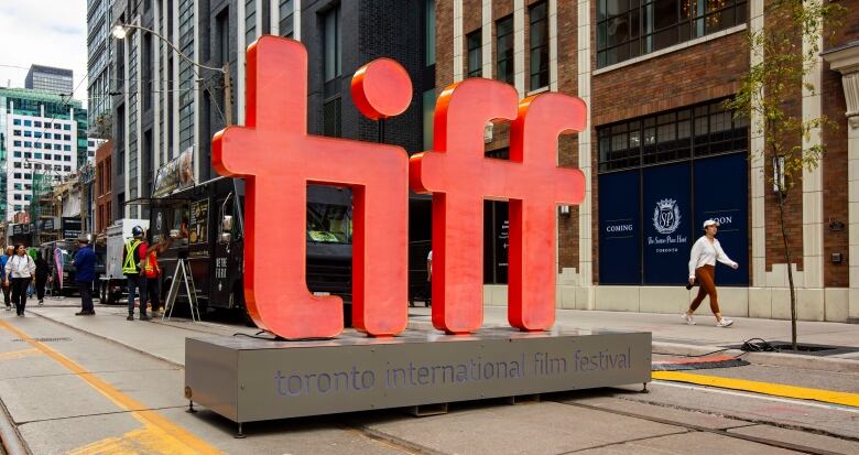 A large red logo reading TIFF stands in the middle of a street.