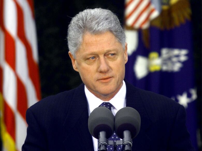 Clinton in front of flags