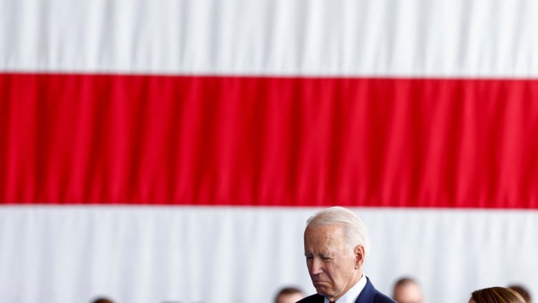 Biden, bowing down in front of flag