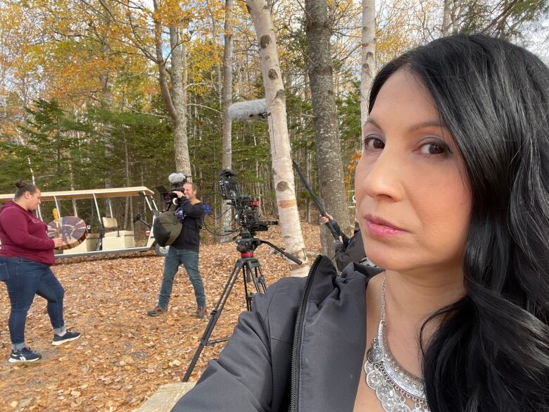 women taking photo in the woods with cast and crew