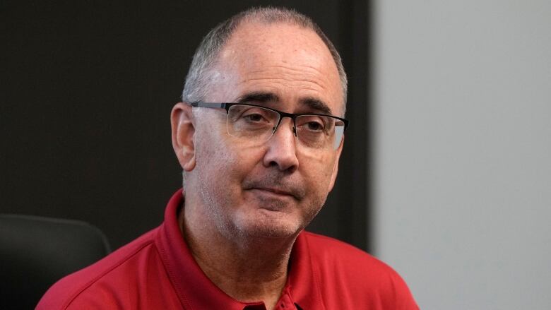 A man with glasses wearing a red shirt.