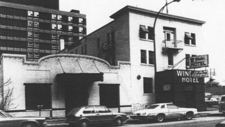 A black and white photo of the exterior of a brick building with the name Windsor Hotel.