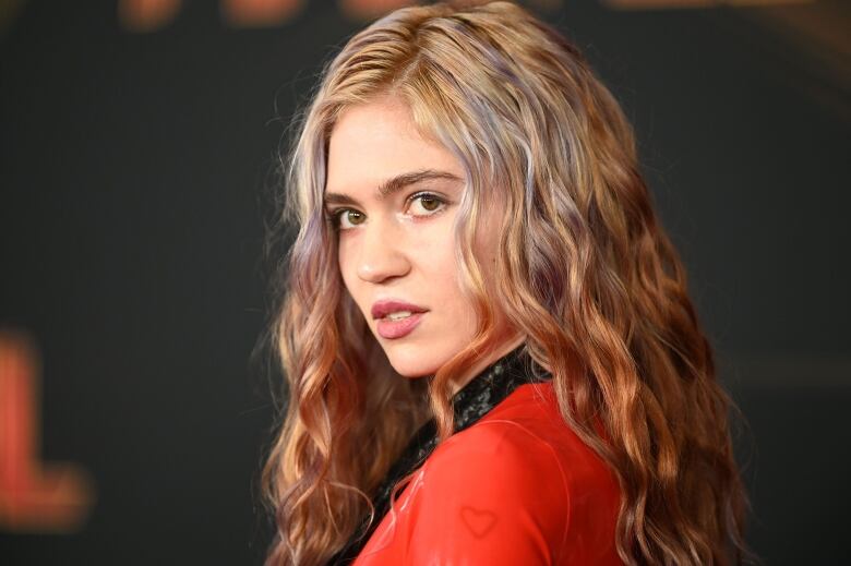 A close-up of a woman wearing red as she poses for photos.