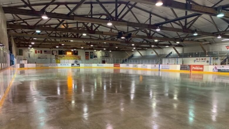 The inside of an arena, without ice, and wooden rafters