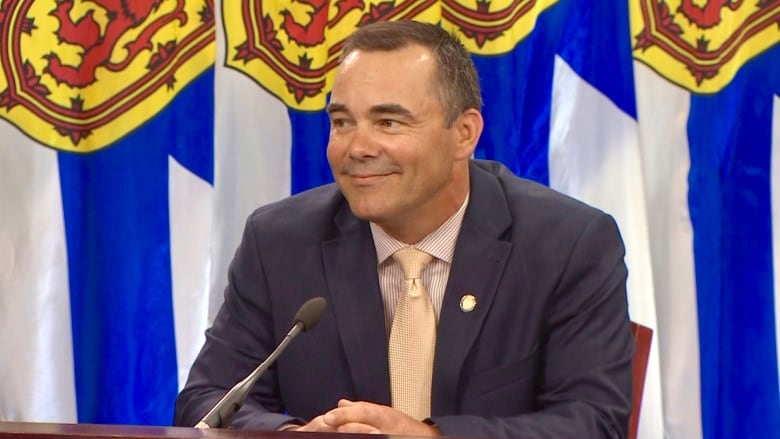 A man in a suit and tie sits at a table.