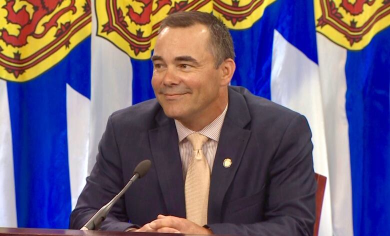 A man in a suit and tie sits at a table.