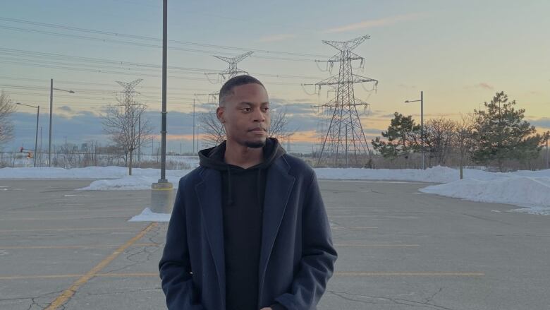 A man stands with snow behind him.