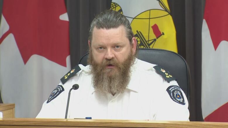 A man sitting at a podium talking into a mic