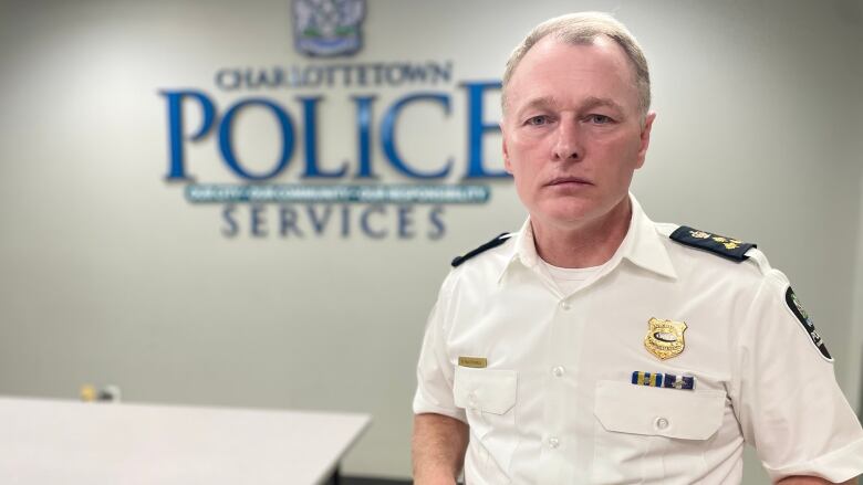 Charlottetown Police Chief Brad McConnell in uniform stands in a room at the police station. 