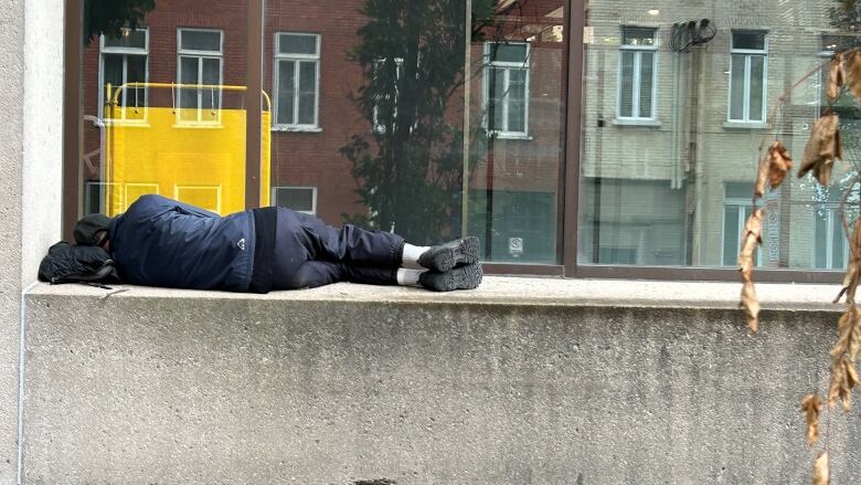 A person lying down on a ledge. 