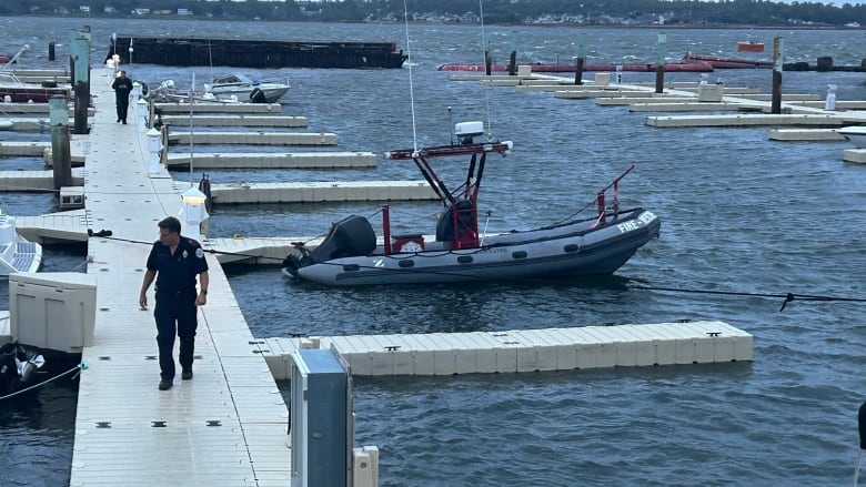 A Charlottetown firefighter inspects the fire department's boat and the area around the Peake's Quay marina Saturday evening.