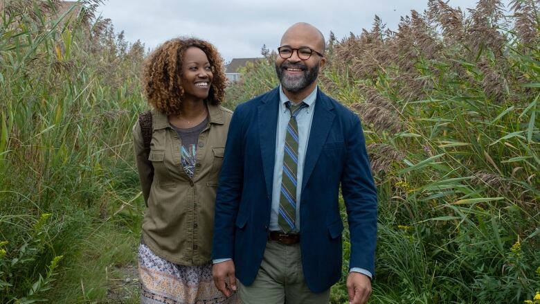 Two people walk in a farmer's field.