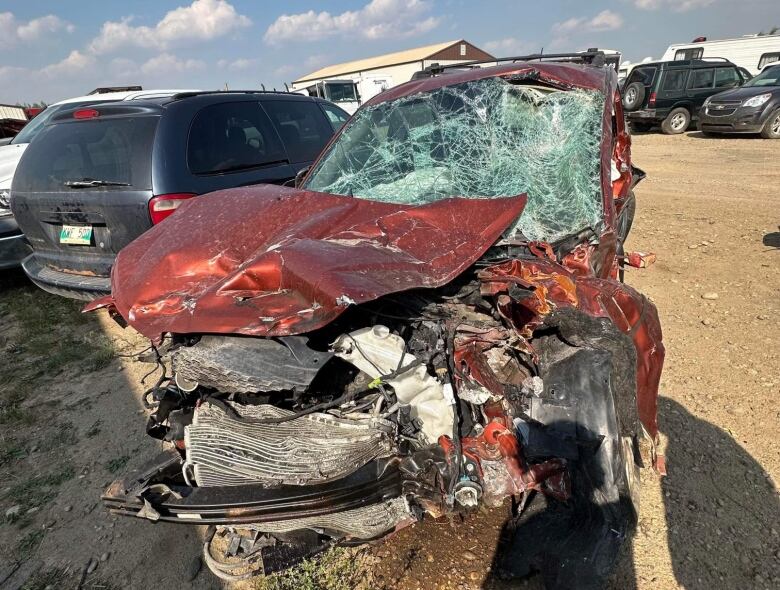 A red SUV with a smashed windshield and its front crumpled in