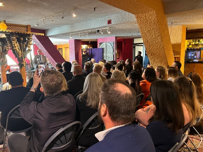 A room full of people seated in chairs at an event.