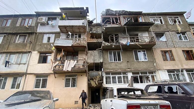 A damaged building and vehicles are shown.