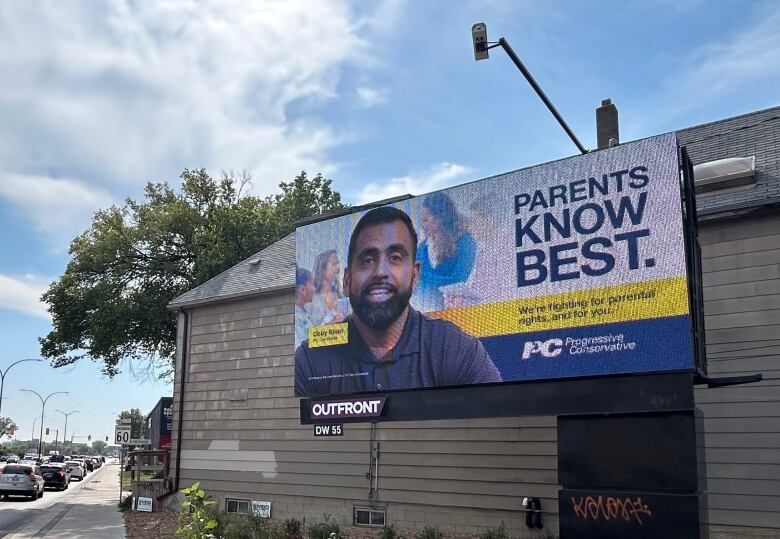 A billboard featuring the face of a Obby Khan with the words 