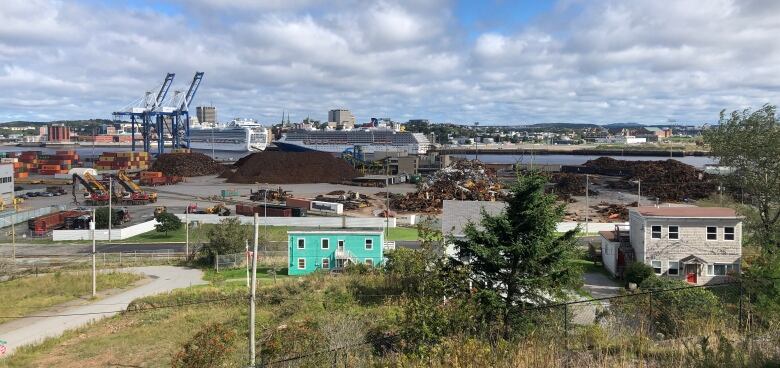 Houses in the foreground and an industrial operation on a dock in the background. 