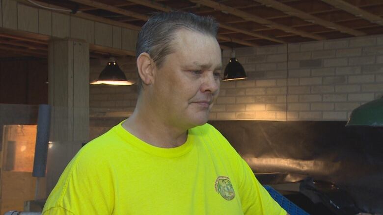 Man in neon green shirt in basement.