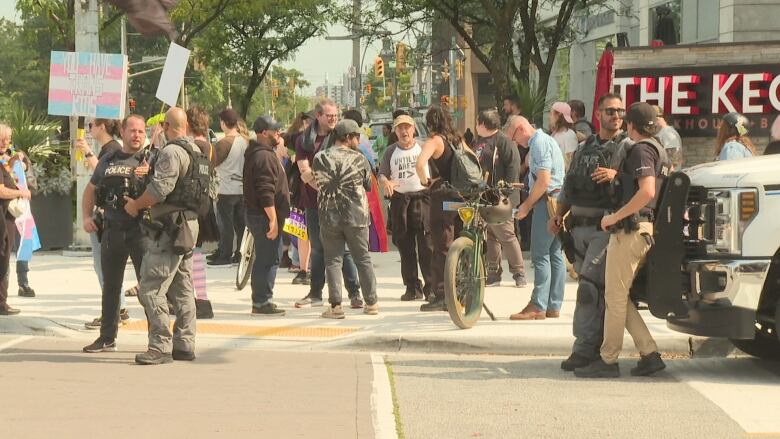 A crowd of people including four police officers