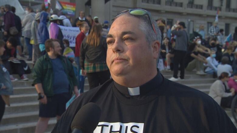 A pastor speaks to media outside a legislature.