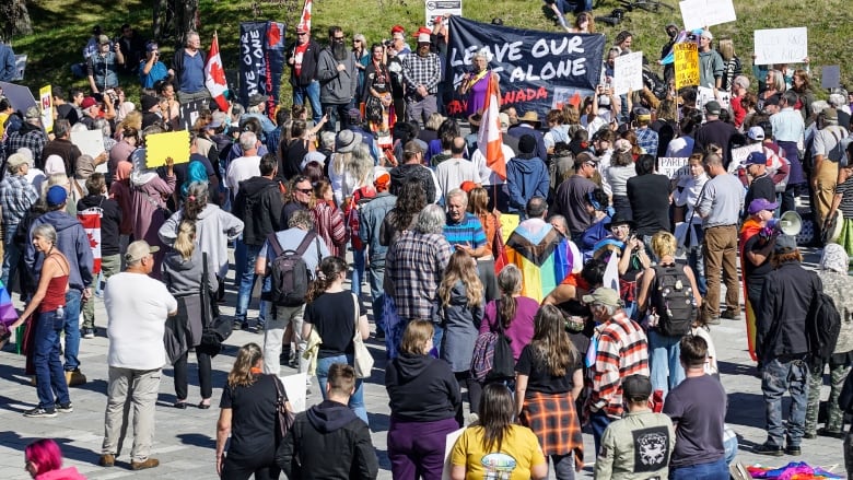 A large group of people standing outside with protest signs.