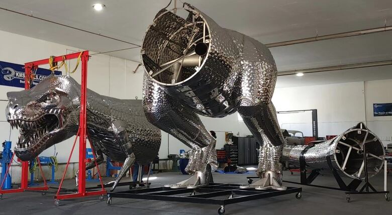 A large metal dinosaur is shown in two pieces side by side: a body and the head/neck.