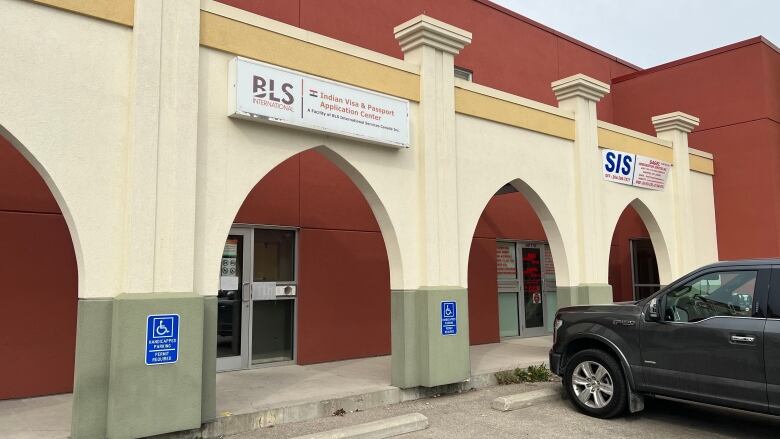 A car is parked outside a building in a parking lot.