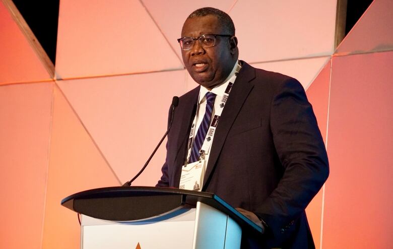 An executive gives a speech from a podium during an oil conference.