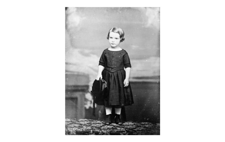 A black and white portrait of a small boy in a dress taken in 1851.