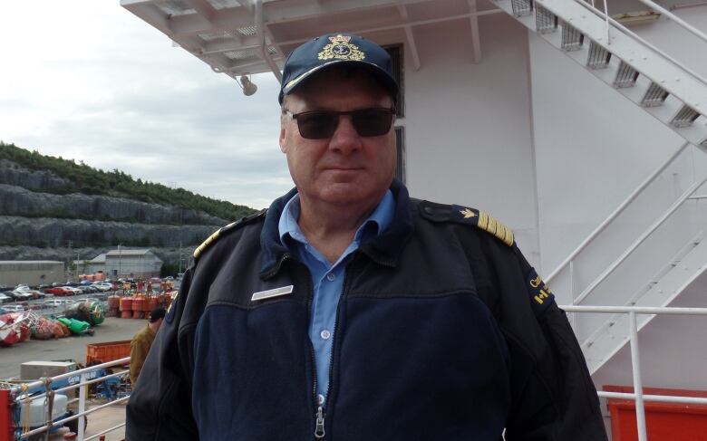 Man in hat and sunglasses on a ship.