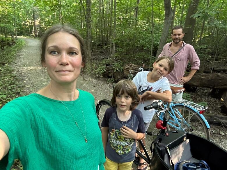 Crystal Waddell holds up her cell phone to take a selfie of her, Luke Shankland and their two children as the lean against their bikes on a local trail. 